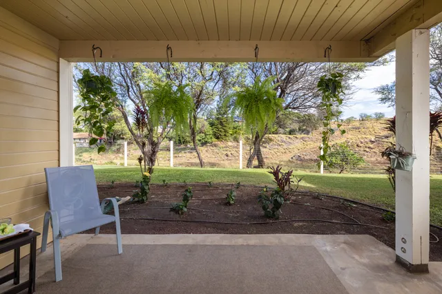 a view of a porch with furniture and a yard