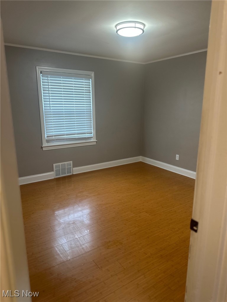 12926 Littleton Road Garfield Heights, OH 44125 - Photo 7 of 12 Unfurnished room featuring crown molding and hardwood / wood-style flooring