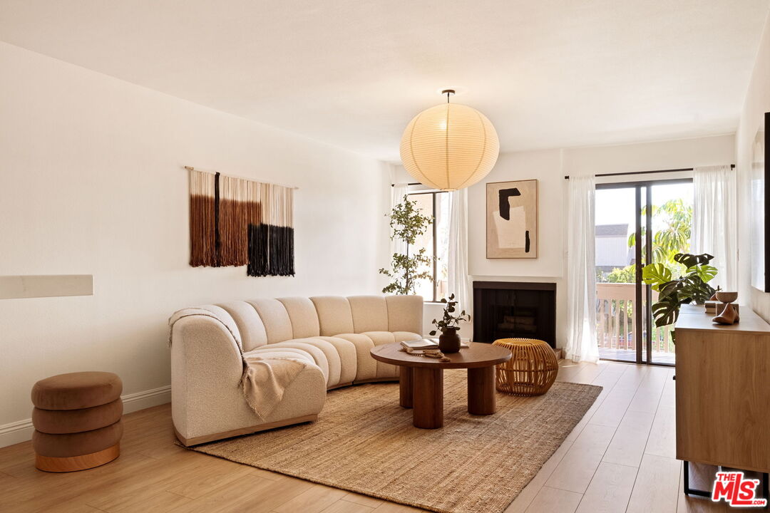 15207 West Magnolia Boulevard, Unit 212 Sherman Oaks, CA 91403 - Photo 1 of 1 a living room with furniture a fireplace and a potted plant