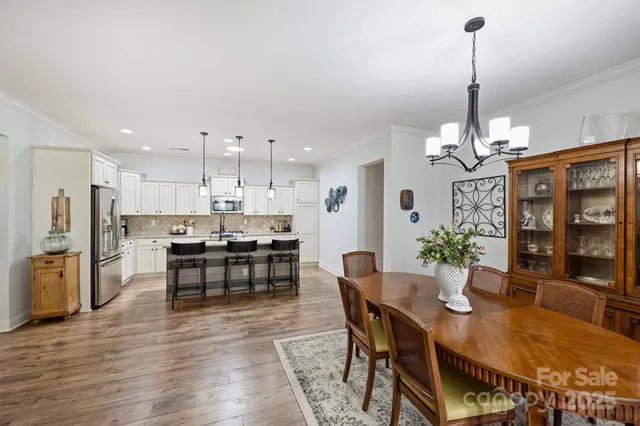 a dining room filled chandelier and wooden floor
