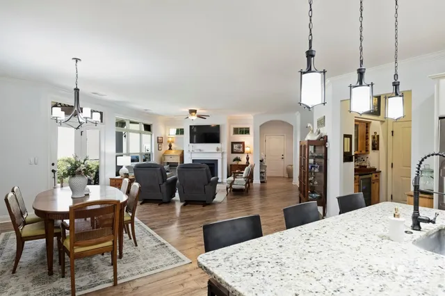a living room with furniture a chandelier and a dining table