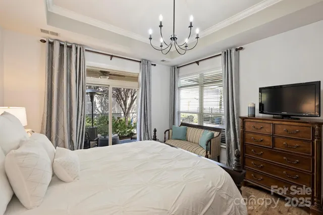 a bedroom with a large bed and a flat tv screen on dresser