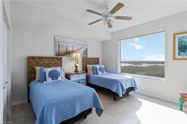 a bedroom with two beds and a large window