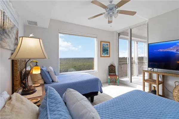 a bedroom with a bed and large window