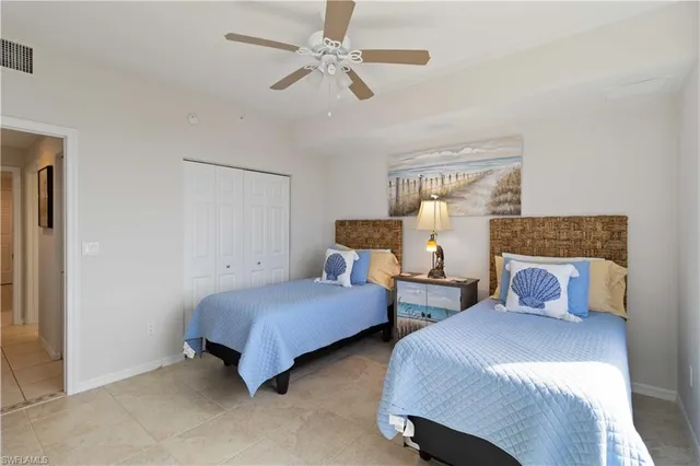 a bedroom with two beds and a chandelier