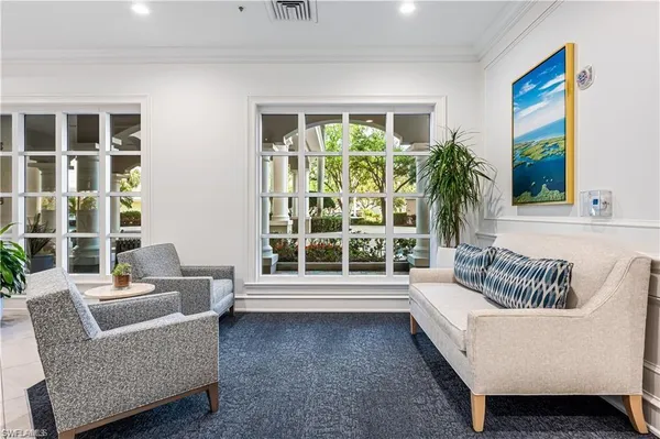 a view of a hallway that has a potted plant on the wall and a mirror