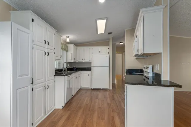 a kitchen with white cabinets and stainless steel appliances