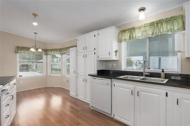 a kitchen with granite countertop a sink a cabinets and window