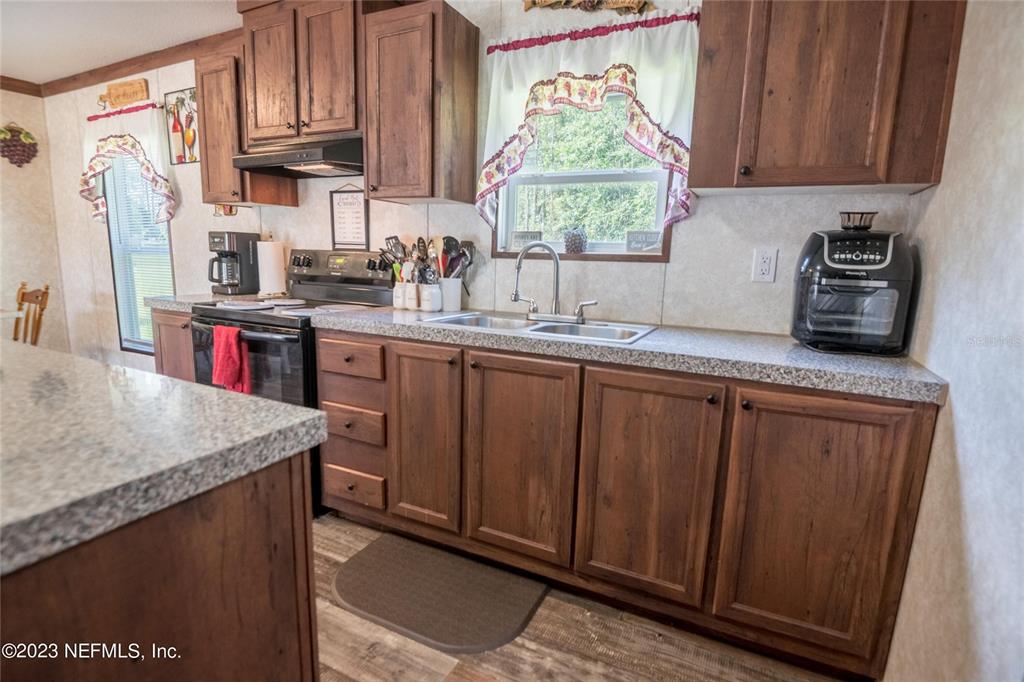 a kitchen with stainless steel appliances granite countertop wooden cabinets a sink and a window