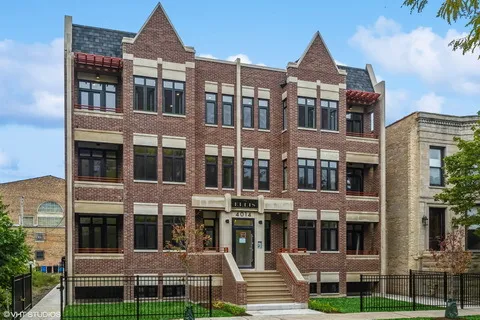 a front view of a residential apartment building with a yard