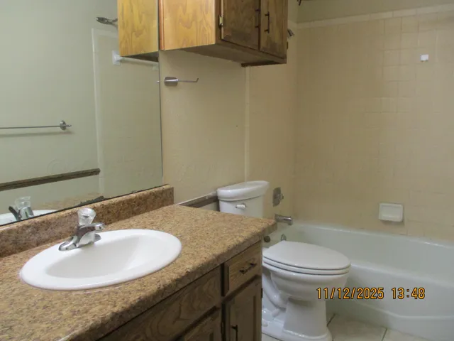 a bathroom with a granite countertop sink toilet and a mirror
