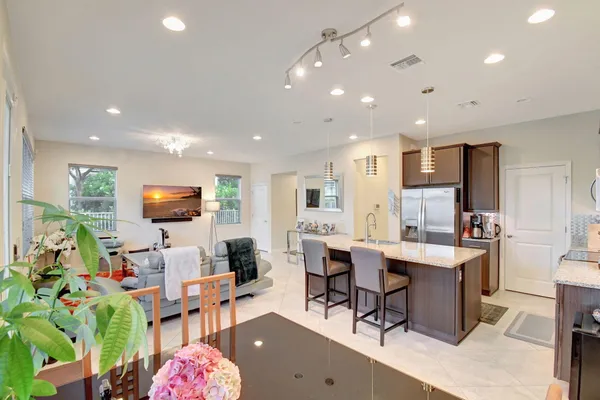 a living room with kitchen furniture and a flat screen tv