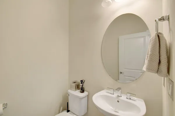 a bathroom with a sink and mirror with toilet