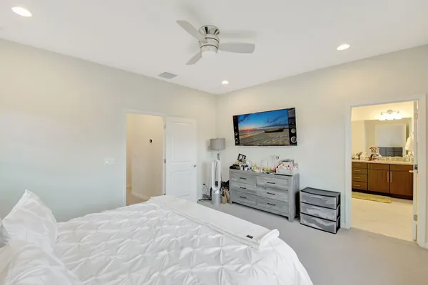 a spacious bedroom with a bed and a flat screen tv
