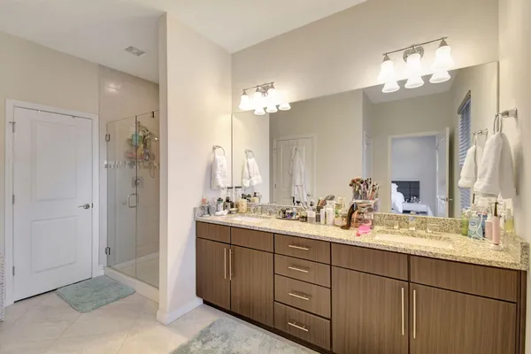 a bathroom with double vanity sinks a vanity a lamp and a mirror