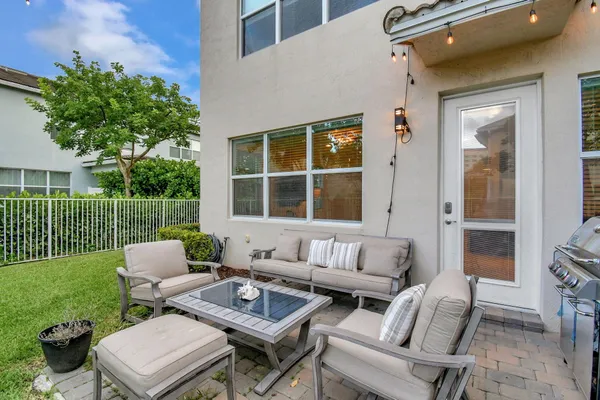a view of a patio with couches table and chairs and potted plants