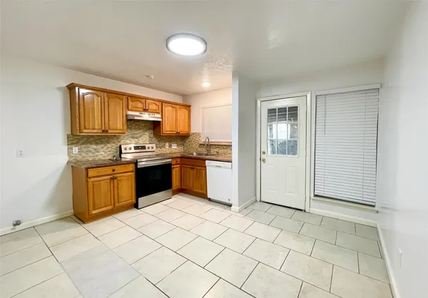 a kitchen with stainless steel appliances granite countertop a stove top oven sink and cabinets