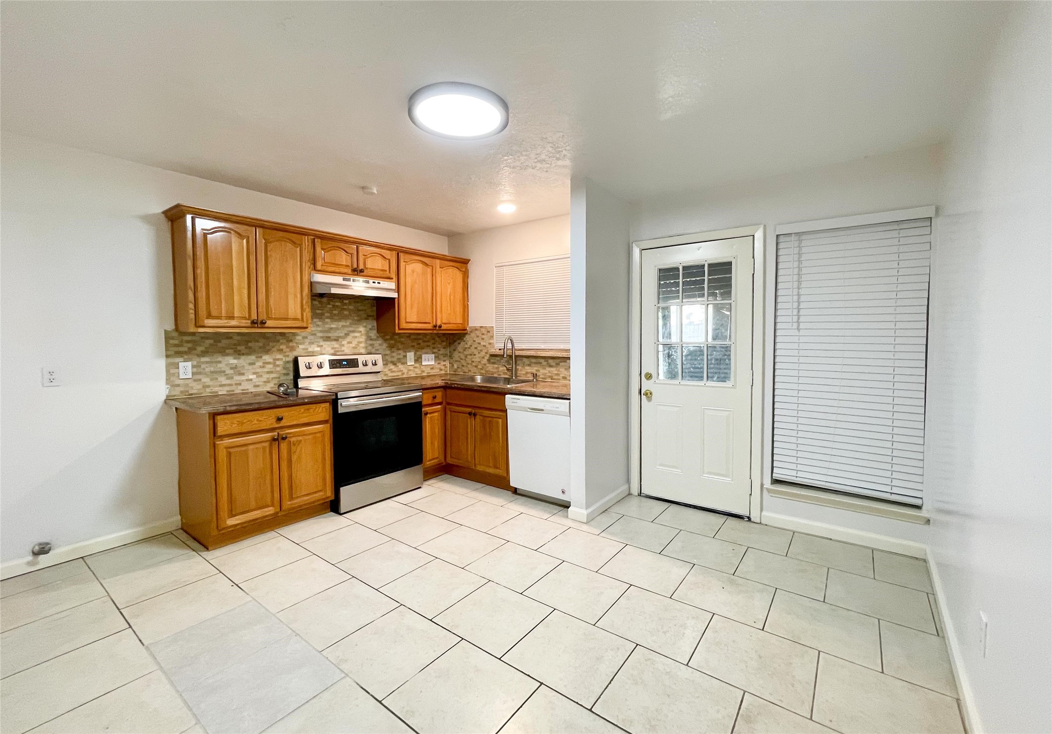 9506 Riverside Lodge Drive Houston, TX 77083 - Photo 13 of 16 a kitchen with stainless steel appliances granite countertop a stove top oven sink and cabinets