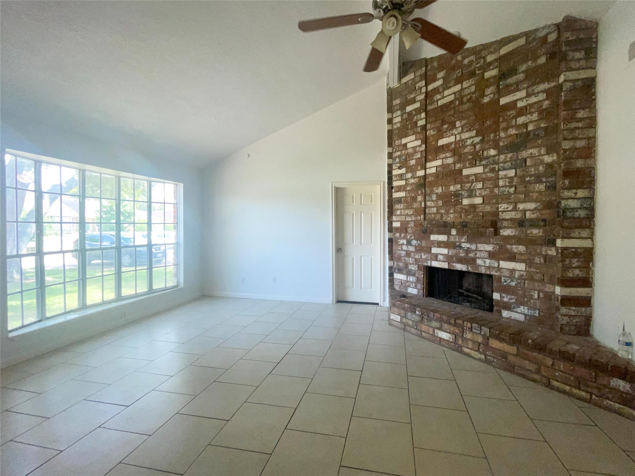 9506 Riverside Lodge Drive Houston, TX 77083 - Photo 3 of 16 a view of an empty room with a fireplace and a window