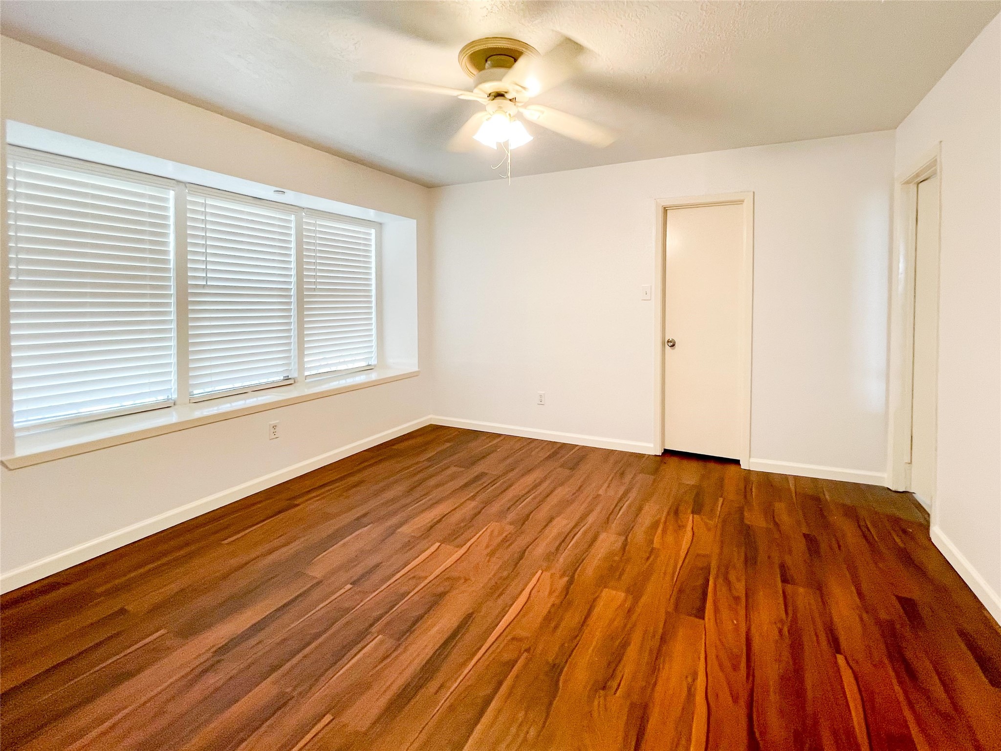 9506 Riverside Lodge Drive Houston, TX 77083 - Photo 5 of 16 a view of a room with wooden floor and a ceiling fan