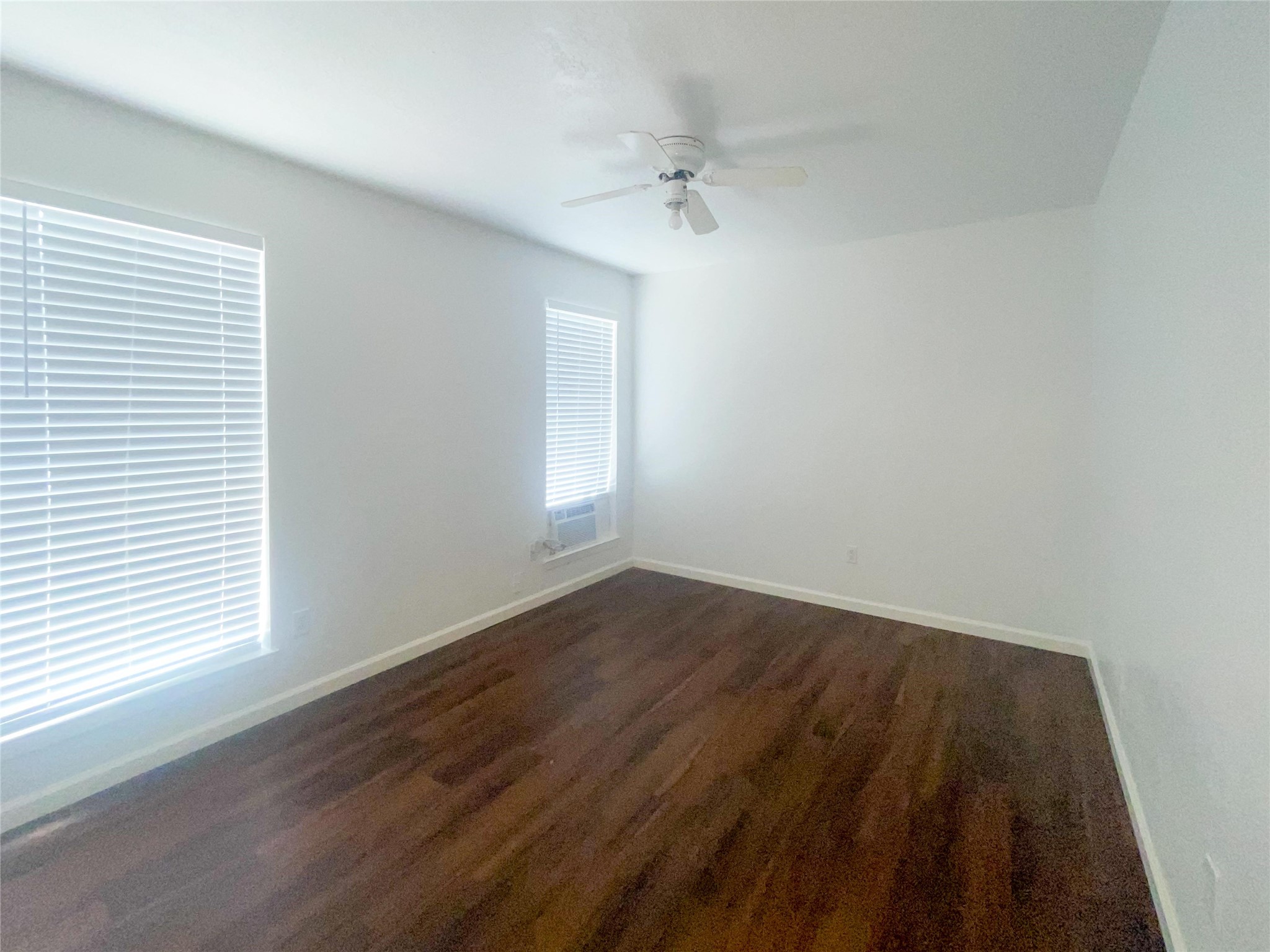 9506 Riverside Lodge Drive Houston, TX 77083 - Photo 8 of 16 an empty room with wooden floor and windows