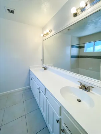 a spacious bathroom with a double vanity sink and mirror