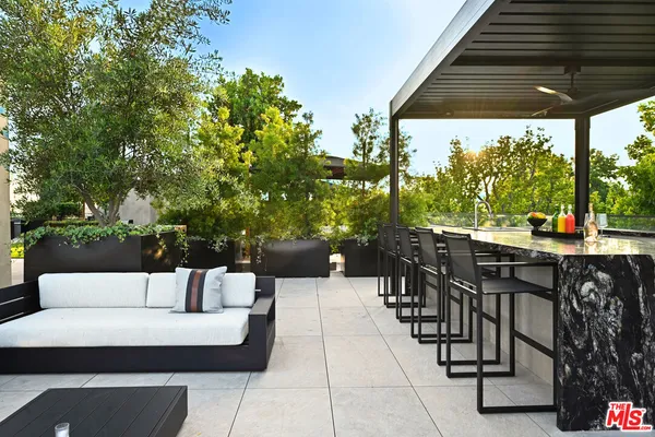 a view of a patio with couches table and chairs and potted plants