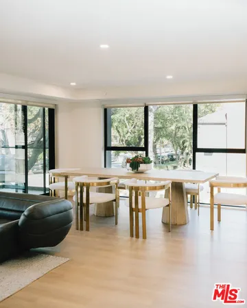 a living room with furniture a large window with kitchen view