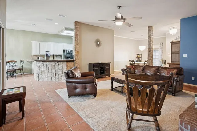 a living room with furniture a fireplace and a kitchen view