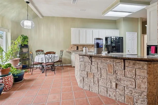 a kitchen with stainless steel appliances a table and chairs in it