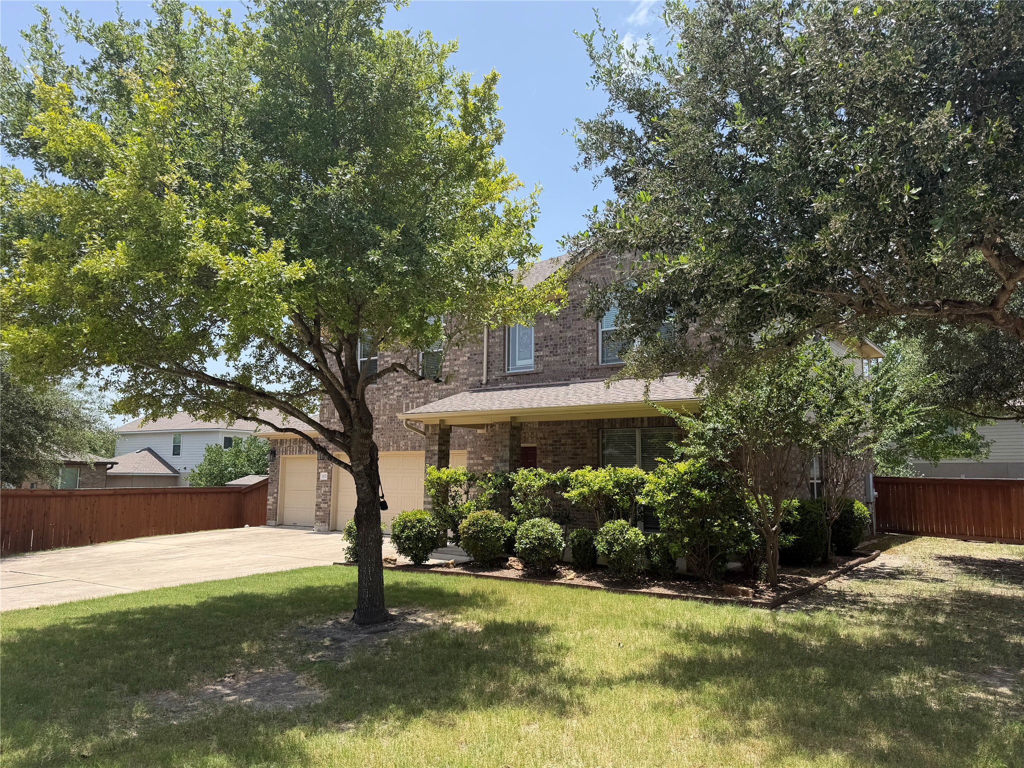 3021 Grand Mission Way Pflugerville, TX 78660 - Photo 2 of 31 Mature trees and lush landscaping frame this traditional brick home with an inviting covered porch.