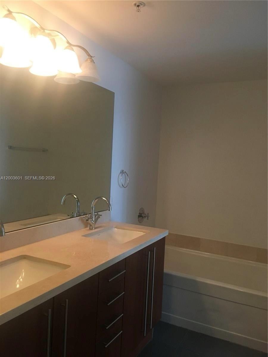 1111 Southwest 1st Avenue, Unit 2223N Miami, FL 33130 - Photo 13 of 39 a bathroom with a sink and a mirror
