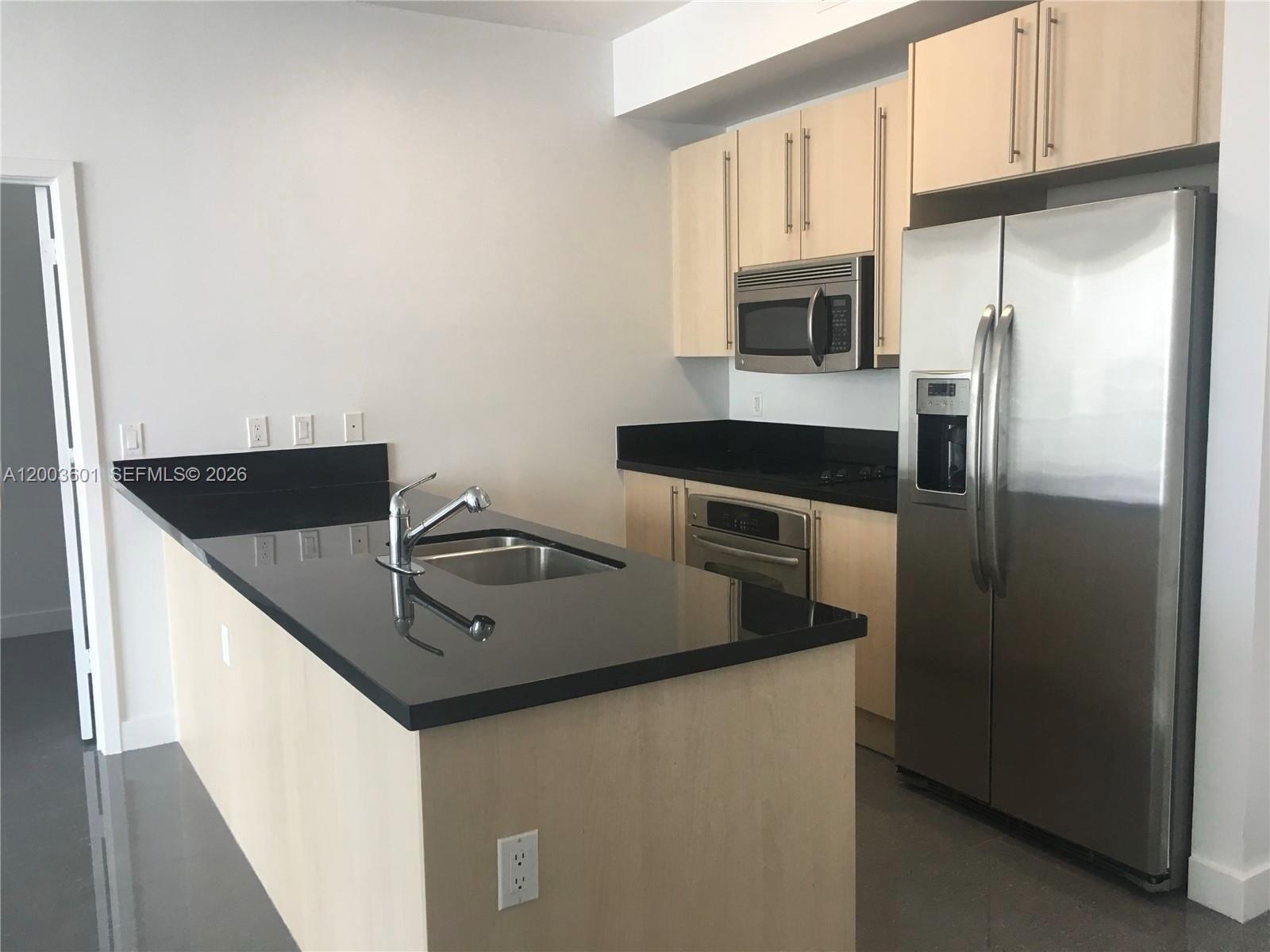 1111 Southwest 1st Avenue, Unit 2223N Miami, FL 33130 - Photo 10 of 39 a kitchen with stainless steel appliances granite countertop a refrigerator a stove and a sink with wooden floor