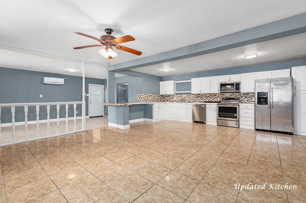 2915 Freeman Street Lufkin, TX 75901 - Photo 11 of 33 a view of a kitchen with a stove cabinets a ceiling fan and wooden floor