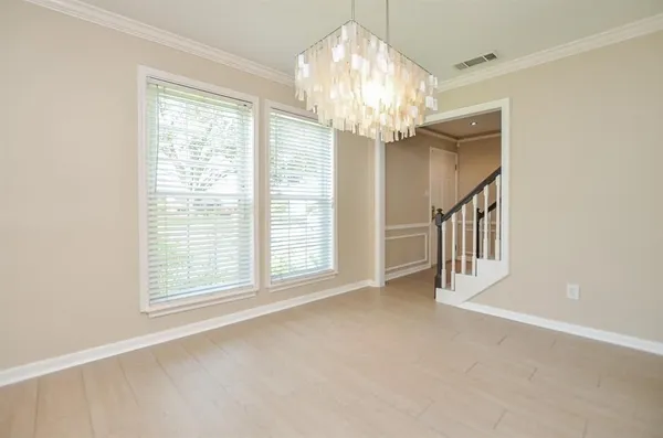 a view of an empty room with a chandelier fan and a window