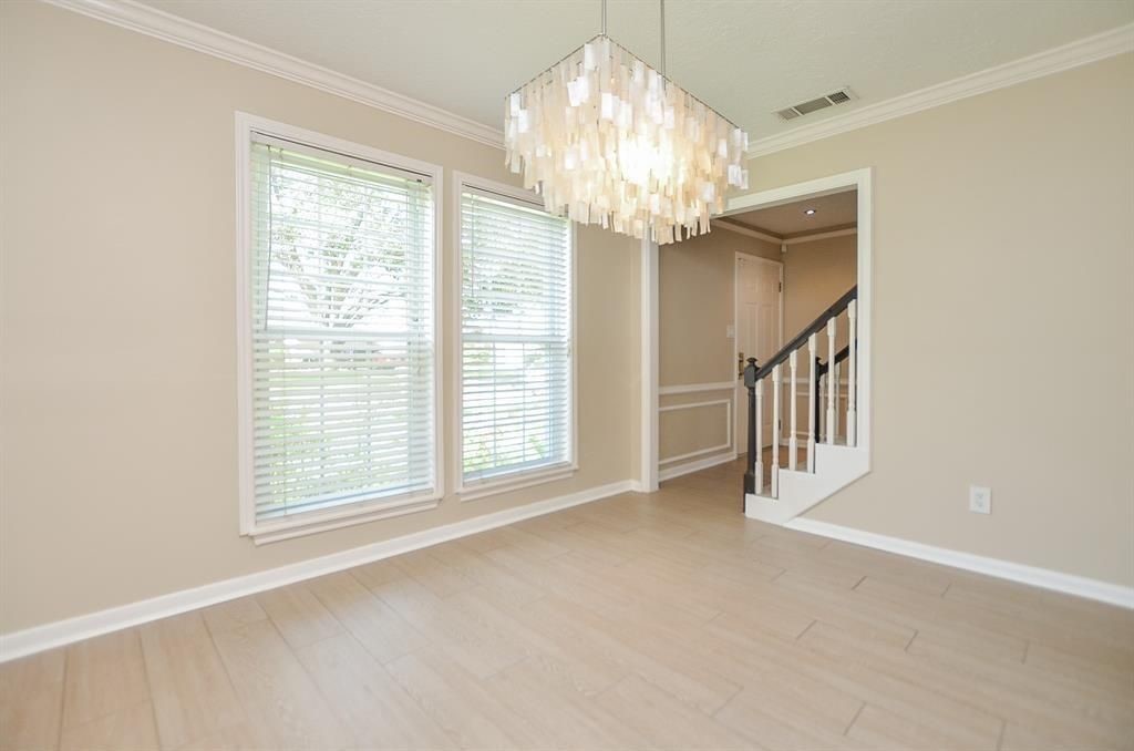11502 Wickersham Lane Houston, TX 77077 - Photo 11 of 22 a view of an empty room with a chandelier fan and a window