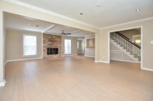 a view of an empty room with fireplace and a window