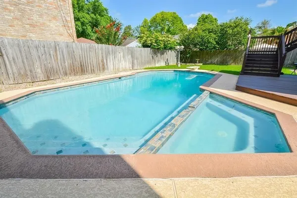 a view of a backyard with swimming pool