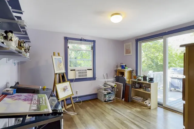 a view of a workspace with furniture and a window