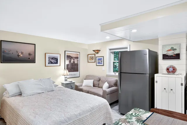 a bedroom with a bed and a refrigerator