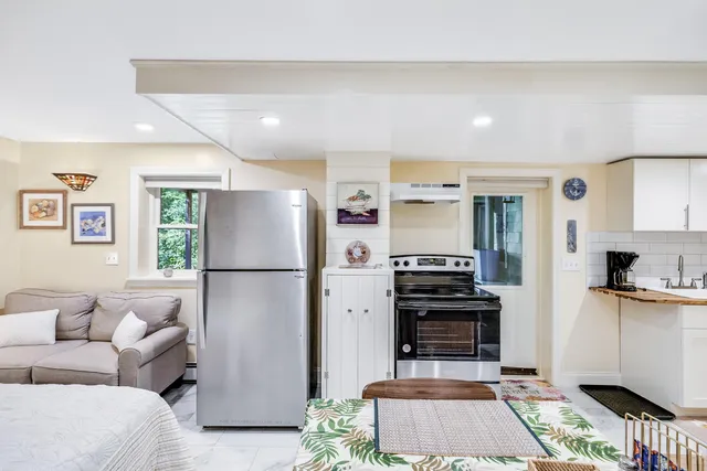 a kitchen with stainless steel appliances a stove a refrigerator and a fireplace