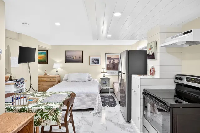 a living room with furniture a flat screen tv and kitchen view