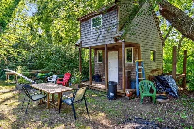 a view of a chair and table in backyard of the house