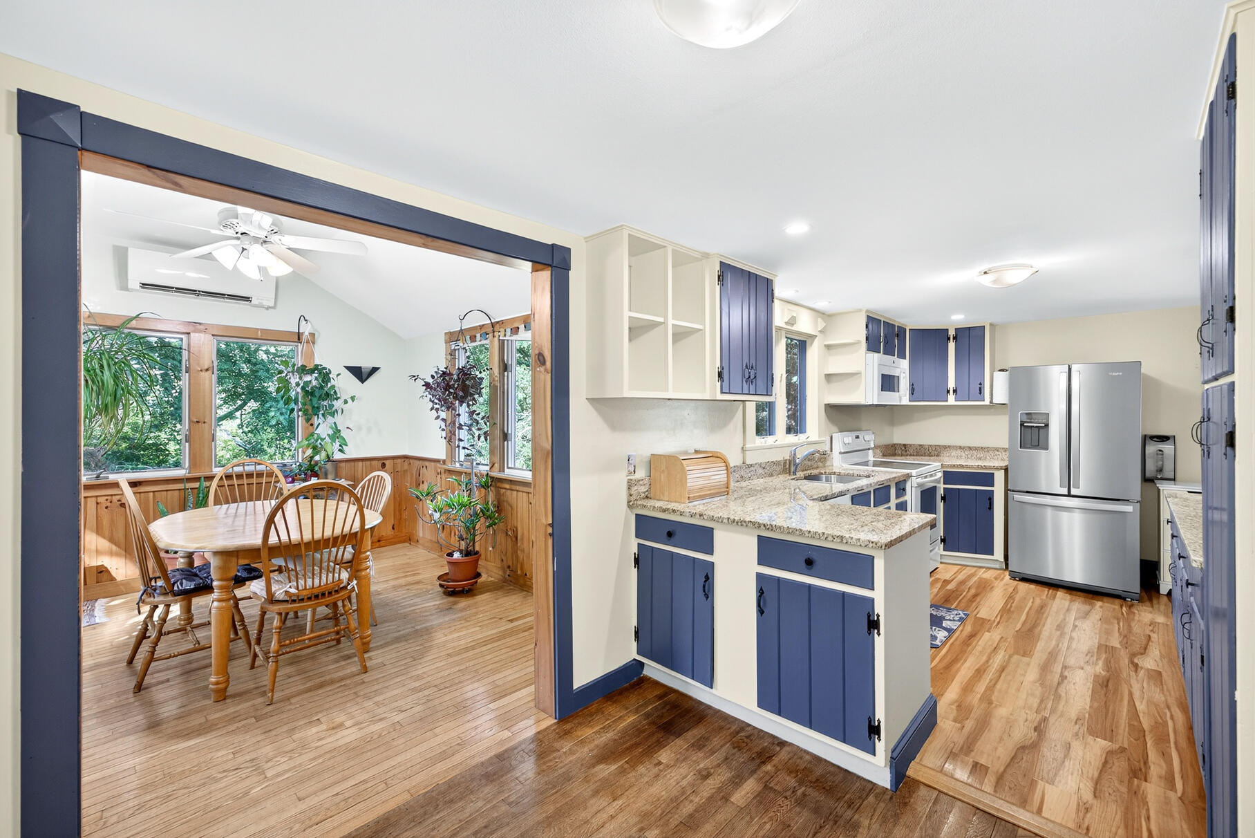 11 Whelpley Road Eastham, MA 02642 - Photo 4 of 37 a open kitchen with stainless steel appliances granite countertop a stove top oven a refrigerator a dining table and chairs with wooden floor