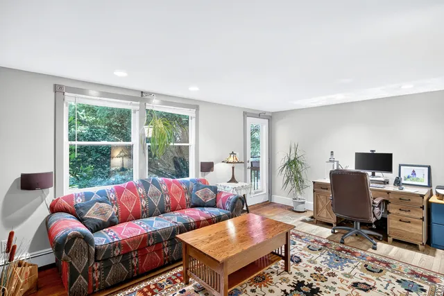 a living room with furniture a rug and a large window