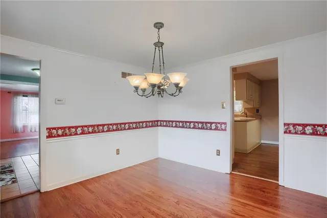 a view of a room with wooden floor and chandelier