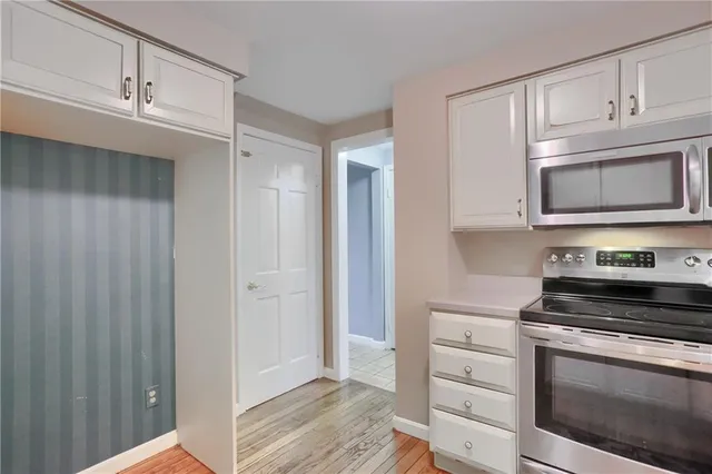 a kitchen with white cabinets and stainless steel appliances