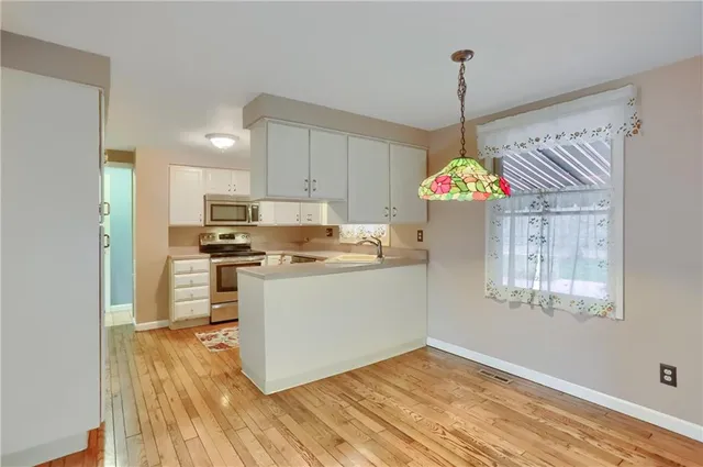 a kitchen view with stainless steel appliances granite countertop a refrigerator and a stove top oven