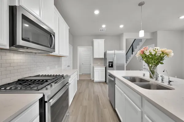 a kitchen with a sink and steel appliances