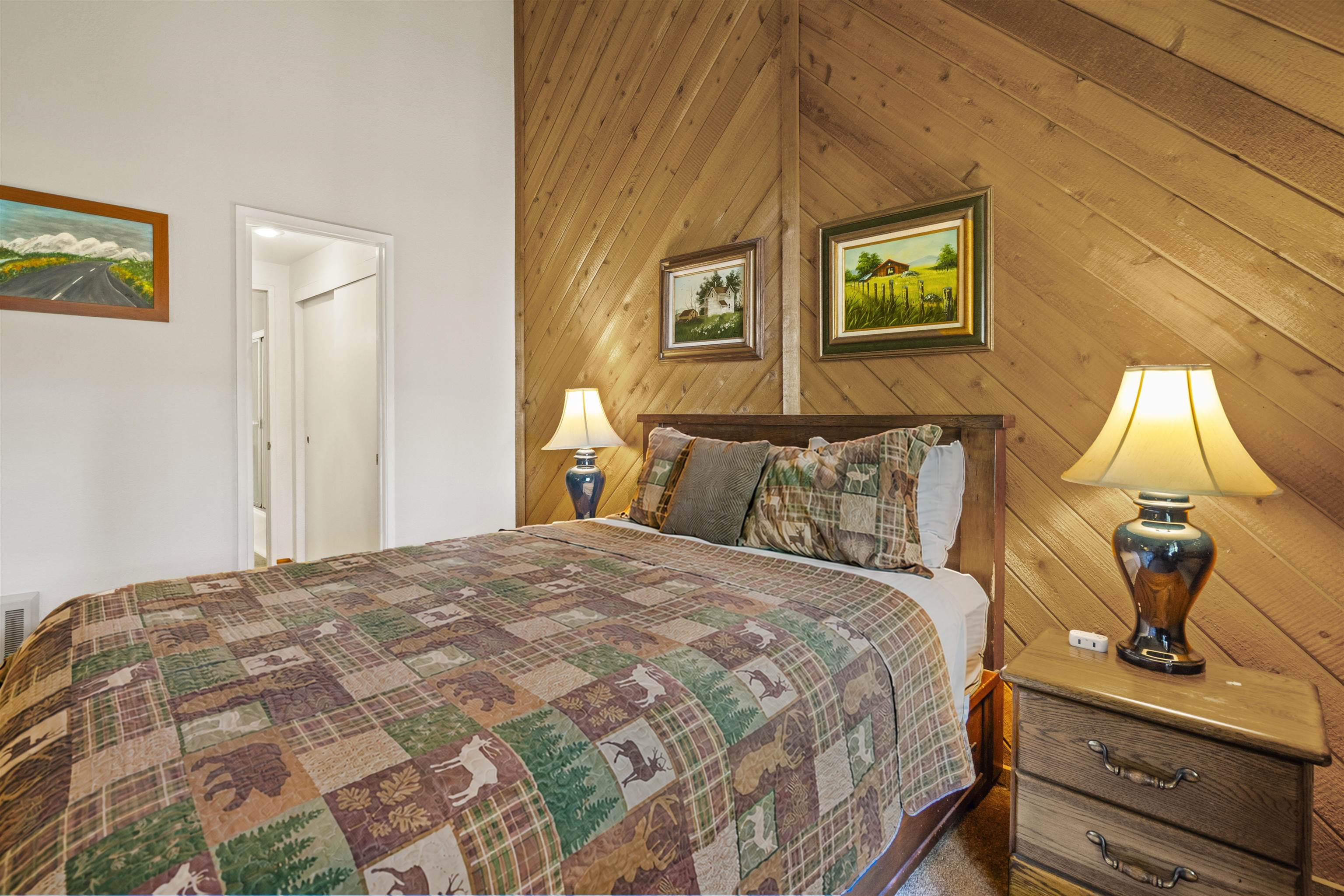 153 Lake Mary Road, Unit 114 Mammoth Lakes, CA 93546 - Photo 8 of 22 Angled wood-paneled wall feature, wood-finish flooring, white painted walls, and an interior doorway providing access to additional spaces